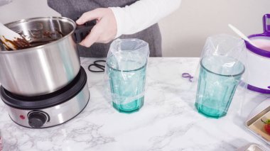 Adım adım. Çikolata parçacıkları eriyen kaplarda eriyor..