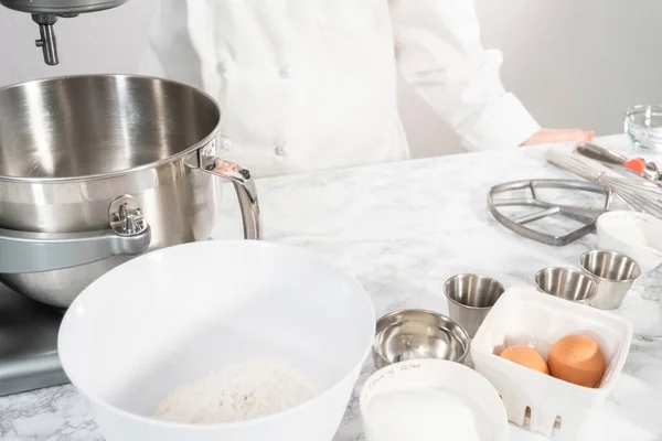 Mixing ingredients in standing kitchen mixer to bake vanilla cupcakes.