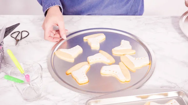 白い色のロイヤルアイシングとアイススケート形の砂糖クッキーを飾る — ストック写真