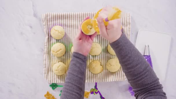 Frosting Vanille Cupcakes Met Italiaanse Boterroom Glazuur Voor Mardi Gras — Stockvideo