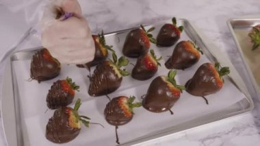 Adım adım. Çikolata kaplı çilek hazırlamak için organik çilekleri erimiş çikolatayla bir kaseye daldırmak..