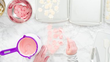 Düz yatıyordu. Adım adım. Erimiş çikolatayı kar taneleri şeklinde plastik bir çikolata kalıbına döküyorum..