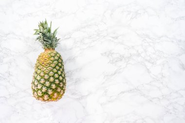Düz yatıyordu. Mermer bir arka planda tüm ananas.
