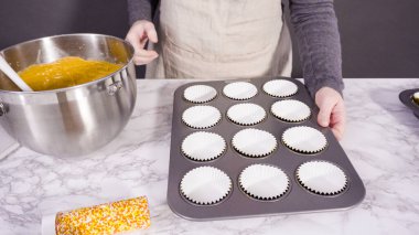 Balkabağı aromalı kek hamuru. Hamur hamuru kepçesiyle kapkek tepsisine dolgu malzemesi..