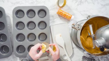 Düz yatıyordu. Balkabağı aromalı kek hamuru. Hamur hamuru kepçesiyle kapkek tepsisine dolgu malzemesi..