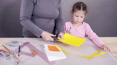 İnşaat kağıdından el yapımı Babalar Günü kartı yapan küçük bir kız..