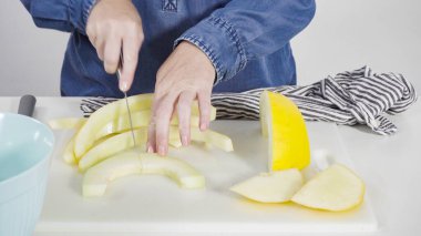 Adım adım. Beyaz kesme tahtasında kaygan altın çiğ taneli kavun.