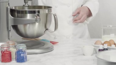 Düz yatıyordu. Kırmızı, beyaz ve mavi üç katlı pasta yapıyorlar..