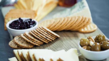 Büyük bir peynir tahtası için tahtanın üzerinde gurme peynir, kraker ve meyve düzenlemek.