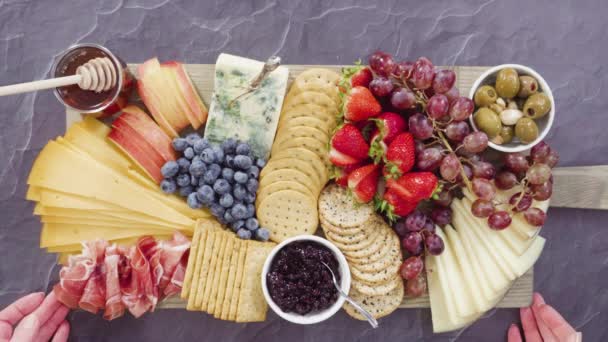 大規模なチーズボードのためのボード上のグルメチーズ クラッカー 果物の手配 — ストック動画