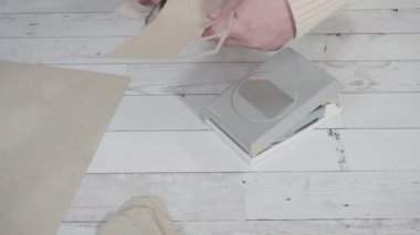 Adım adım. Kahverengi kağıttan hediye etiketlerini kağıt punçla kesiyor..