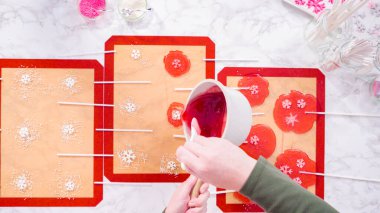 Düz yatıyordu. Ev yapımı lolipoplar yapmak için silikon paspaslara karamelize şeker dökmek..