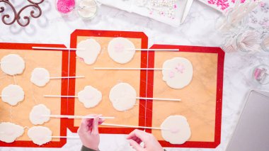 Düz yatıyordu. Büyük ev yapımı lolipopları silikon minderden soyuyorlar..