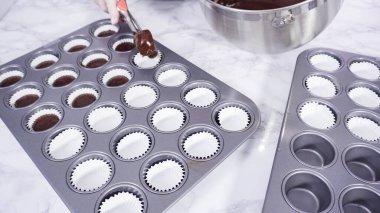 Adım adım. Mini çikolatalı kekler pişirmek için kek hamurunu mini kek kuyruklarına karıştırmak..