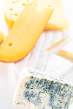Beyaz arkaplanda geniş kama gurme peyniri çeşitliliği.