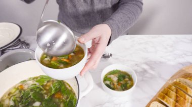 Beyaz kaselerde vejetaryen beyaz fasulye çorbası servis ediyorlar..