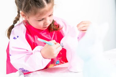 Küçük kız COVID-19 salgınında evde uzaktan öğrenim için sanat projesi üzerinde çalışıyor..