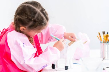 Küçük kız COVID-19 salgınında evde uzaktan öğrenim için sanat projesi üzerinde çalışıyor..