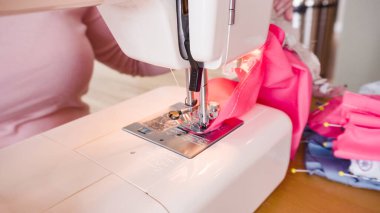 Koronavirüs salgını için dikiş makinesiyle pamuk yüz maskesi dikiyorum..