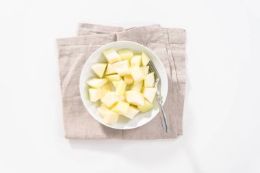 Düz yatıyordu. Beyaz bir kasede dilimlenmiş altın çiğ taneli kavun..