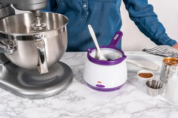 Mixing ingredients in a standing kitchen mixer to make homemade chocolate ice cream.