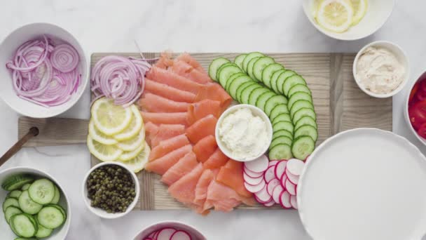 スモークサーモンと新鮮な野菜のベーグルブランチボード — ストック動画