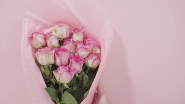 Bouquet Rose Rosa Fresche Avvolgente Una Carta Rosa Sfondo Bianco — Video Stock