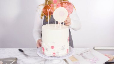 Süslenmek için uzun beyaz yuvarlak pastanın içine kar taneli büyük lolipoplar yerleştiriyoruz..