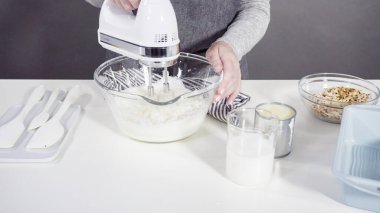 Ev yapımı hindistan cevizli dondurma hazırlamak için karıştırma kabındaki malzemeleri karıştırıyorum..