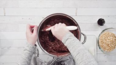 Basit çikolatalı şekerlemeler yapmak için yemek kabındaki malzemeleri karıştırıyorum..