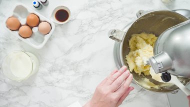 Adım adım. Düz yatıyordu. Üç katlı vanilyalı kek pişirmek için mutfak mikserinin malzemelerini karıştırıyorum..