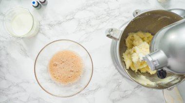 Adım adım. Düz yatıyordu. Üç katlı vanilyalı kek pişirmek için mutfak mikserinin malzemelerini karıştırıyorum..