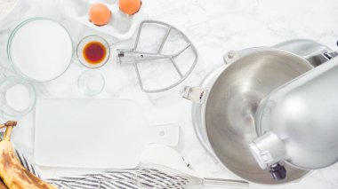 Düz yatıyordu. Adım adım. Muz ekmeği pişirmek için malzemeleri metal karıştırma kabına karıştırıyorum..