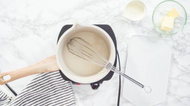 Düz yatıyordu. Adım adım. Pişirme kabında ev yapımı karamel hazırlanıyor.