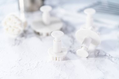 Mermer bir yüzey üzerinde kar tanesi şeklindeki kurabiye kesicilerin yakın görüntüsü.