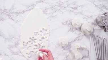 Düz yatıyordu. Adım adım. Mermer tezgahın üzerindeki beyaz fondanla kar tanelerini keserek..