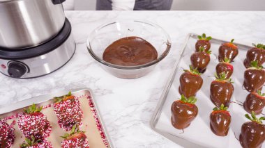 Adım adım. Erimiş çikolataya organik çilek batırmak..