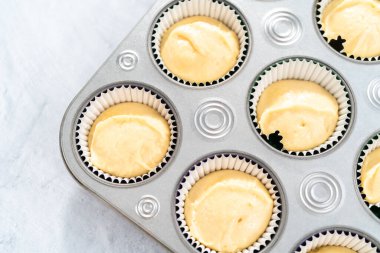 Mardi Gras vanilyalı kek pişirmek için folyolu kek dilimli vanilyalı kek hamuru..