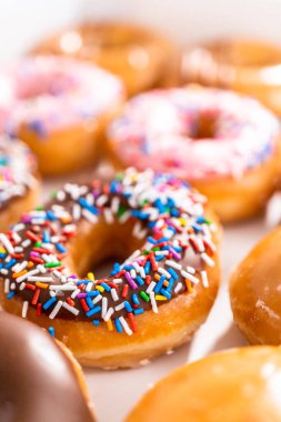 Beyaz bir karton kutuda mağazadan alınmış donutların çeşitliliği.