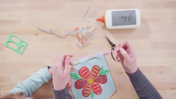 妈妈教孩子们如何在手工桌旁用简单的缝纫工具缝制衣服 — 图库视频影像