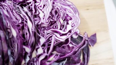 Ağaç kesme tahtasında yeşil lahana öğütüyorum..