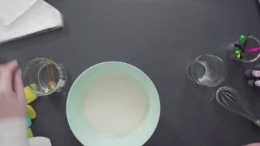 Tek boynuzlu at temalı vanilyalı kekleri süslemek için renkli krema kremalı boru torbaları hazırlanıyor..