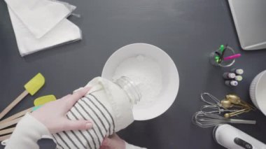 Tek boynuzlu at temalı vanilyalı kekleri süslemek için renkli krema kremalı boru torbaları hazırlanıyor..