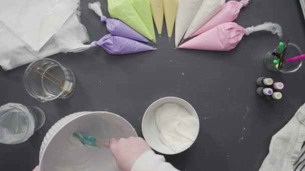 为装饰独角兽主题香草纸杯蛋糕 用五颜六色的奶油糖霜制作管道袋 — 图库视频影像