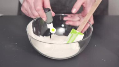 Tek boynuzlu at temalı vanilyalı kekleri süslemek için renkli krema kremalı boru torbaları hazırlanıyor..