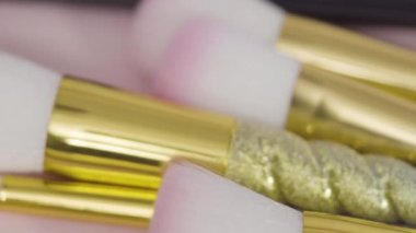 Beyaz arka planda tek boynuzlu at temalı makyaj fırçaları ve göz falı paleti.