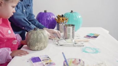 Küçük kız evde eğitim projesi için akrilik boyayla heykelcikler boyuyor..