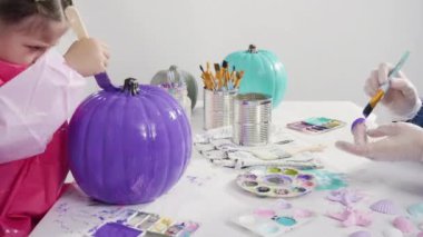 Küçük kız evde eğitim projesi için akrilik boyayla heykelcikler boyuyor..