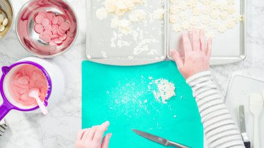 Düz yatıyordu. Adım adım. Fazla çikolatayı, kar taneleri şeklindeki çikolatalardan küçük bir mutfak bıçağıyla budamak..