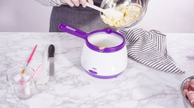 Adım adım. Çikolatalı şekerleri eritmek elektrikli bir şeker tenceresinde erir..